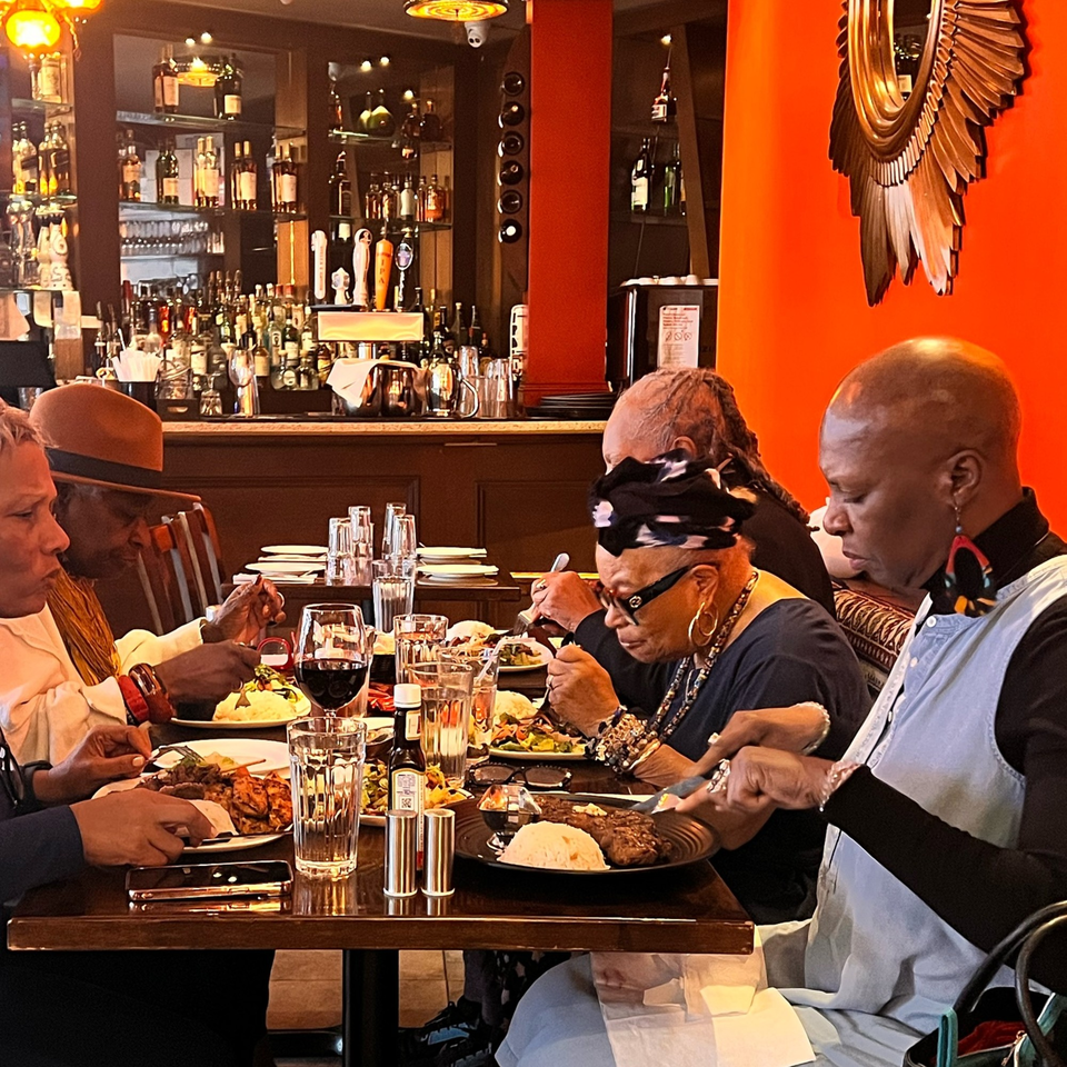 Diverse group of people enjoying Turkish cuisine at Deniz Mediterranean Turkish Cuisine restaurant.